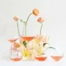 glasses of rosé wine among a small display of spring flowers on a white backdrop
